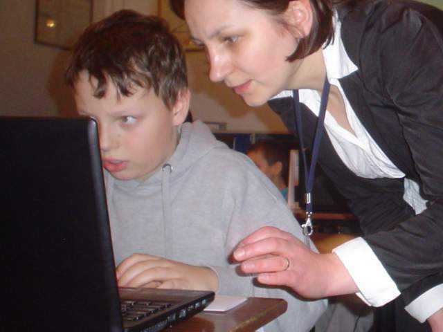 Pracownik banku udziela uczniom wskazówek, jak korzystać z kont internetowych SKO